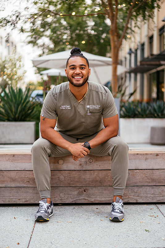 Levi Powell wearing brown scrubs in his campus