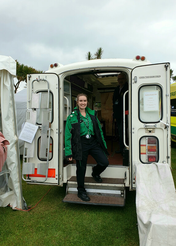 Beth Franks in training posing next to an ambulance