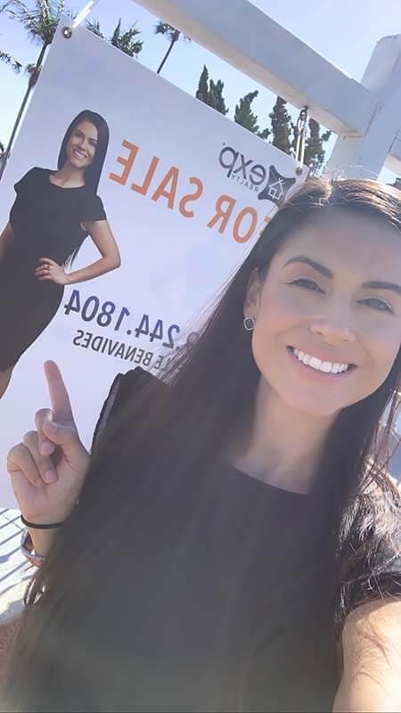 Danielle Benavides posing in front of one of her listings