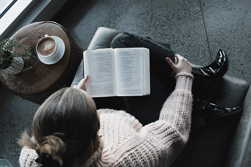 A woman reads a book in a cafe