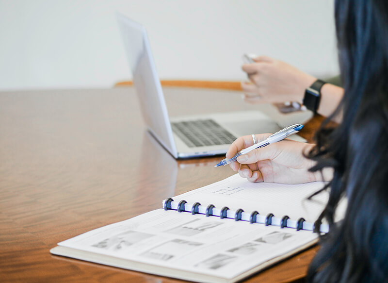 Female college student taking down notes on case study parts