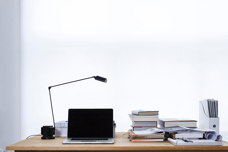 An empty working station chair with an opened laptop