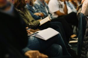 student at a lecture taking notes