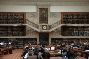 students writing and studying in a library and gaining the benefits of writing assistants