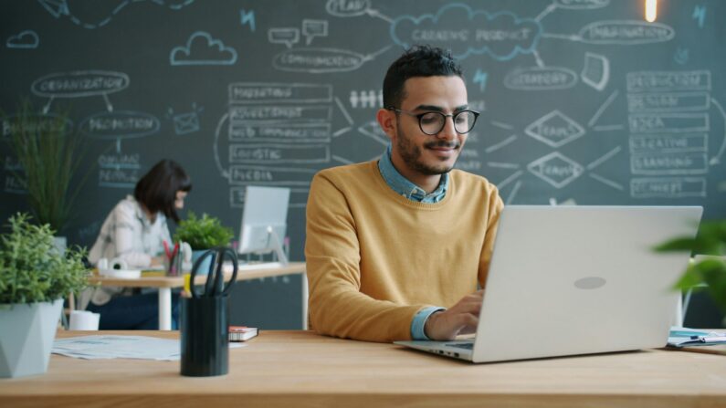 A student using AI writing tools on a laptop to learn how to make AI writing sound human.
